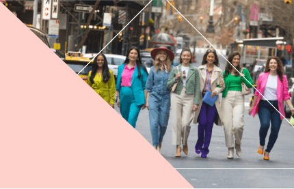 six women walking in the street, smiling